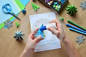Making greeting card with origami 3D Xmas tree from paper. Merry Christmas and Happy New Year decoration. Childrens DIY concept.