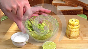 Making guacamole dip from guacamole mexican vegetables. Male chef hands preparing guacamole recipe, hands mashing