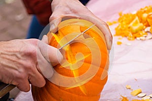 Making a halloween pumpkin Jack-o`-lantern with a knife