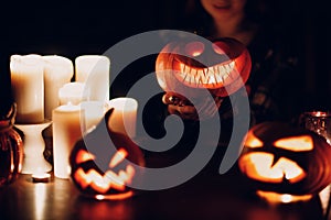 Making Halloween pumpkin Jack-o-lantern. Pumkins and candles on table