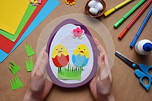 Making of handmade Easter decoration. Child made greeting card in egg shape. Childrens DIY concept, gift with your own hands.