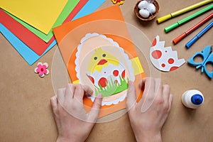 Making of handmade Easter decoration. Child made greeting card in egg shape. Childrens DIY concept, gift with your own hands.