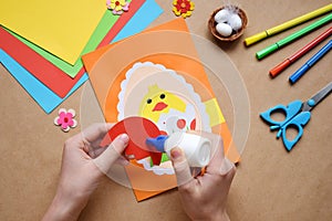 Making of handmade Easter decoration. Child made greeting card in egg shape. Childrens DIY concept, gift with your own hands.