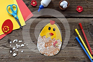 Making of handmade Easter decoration. Child made greeting card from eggshell. Childrens DIY concept, gift with your own hands.