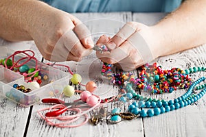 Making of handmade jewellery, front view of male hands