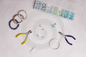 Making of handmade jewellery. Top view. Beads, tools for creating jewelry. Preparation for handmade. Create jewelry, bracelets