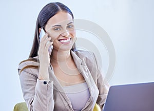 Making it happen with a few calls. a young businesswoman talking on a cellphone while working on a laptop in an office.