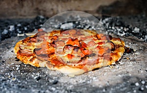 Making of homemade Italian pizza in fireplace brick oven