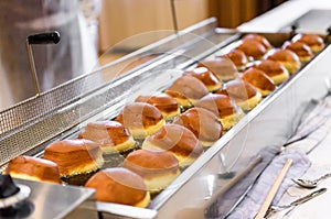 Making homemade jam doughnuts in a professional restaurant buff photo