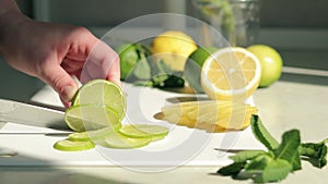Making homemade non-alcoholic mojito. Cut a lime into slices close-up