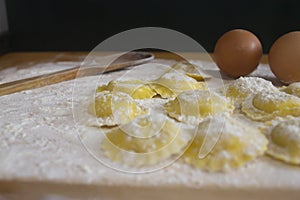 Making homemade Ravioli / Tortellini /dumpling with eggs on floured wood
