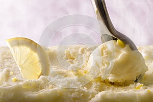 Making lemon ice cream ball with scoop front view
