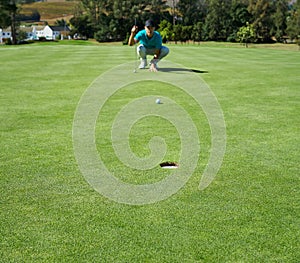 Making this look easy. Shot of a focused young man waiting for the golfball he just hit to go into a hole outside on a