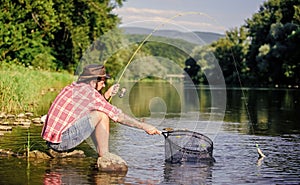 Making me happy. mature bearded man with fish on rod. successful fisherman in lake water. hipster fishing with spoon
