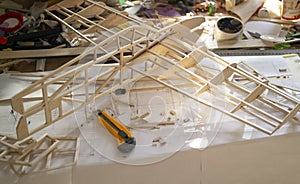 Making model airplane from balsa wood. handcrafted on work table photo