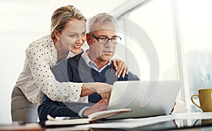 Making monthly budgeting a breeze with modern tech. a mature couple using a laptop while going through paperwork at home