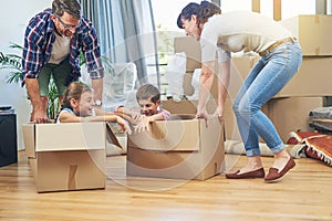 Making moving day a family friendly activity. Shot of a happy family having fun together on moving day.