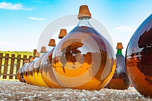 Making of natural sweet dessert muscat liqueur white wine outside in big round glass antique demijohn bottles in Frontignan, south