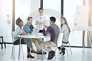 Making a note of the teams suggestions. a businesswoman giving a presentation to her colleagues in a modern office.