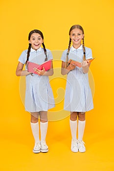 Making notes. small girls love literature. old school. happy friends in retro uniform. vintage kid fashion. back to