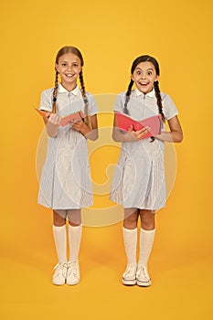 Making notes. small girls love literature. old school. happy friends in retro uniform. vintage kid fashion. back to