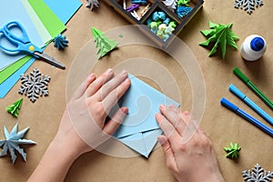 Making origami 3D Xmas tree with paper for decoration or greeting card. Merry Christmas and Happy New Year. Children DIY concept