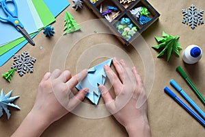 Making origami 3D Xmas tree with paper for decoration or greeting card. Merry Christmas and Happy New Year. Children DIY concept