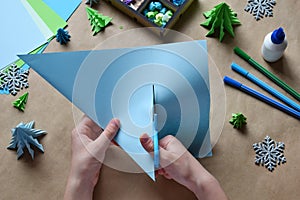 Making origami 3D Xmas tree with paper for decoration or greeting card. Merry Christmas and Happy New Year. Childrens DIY concept