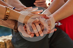 Making a pact to stay friends forever. a group of unidentifiable friends putting their hands in a pile at an outdoor