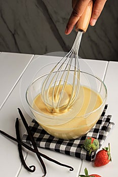 Making Pancakes, Cake, Baker Hands Pouring Batter and Whisking Batter in Bowl. Concept of Cooking Ingredients and Method on White