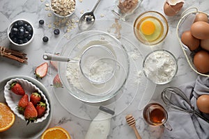 Making pancakes, cake, baking of baker hands pouring or sifting flour in bowl. Concept of Cooking ingredients and method on white