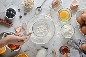 Making pancakes, cake, baking of baker hands pouring or sifting flour in bowl. Concept of Cooking ingredients and method on white