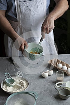 Making pancakes with chef. Chef at his workplace with cooking inventory and ingridients on a background