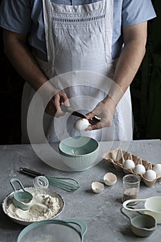 Making pancakes with chef. Chef at his workplace with cooking inventory and ingridients on a dark background