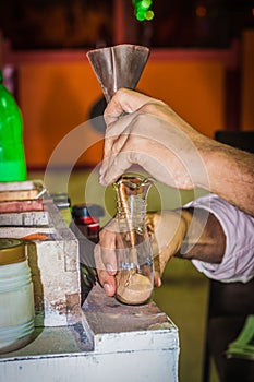 Making a picture of sand in a bottle. Male hands closeup. Hurghada, Egypt.