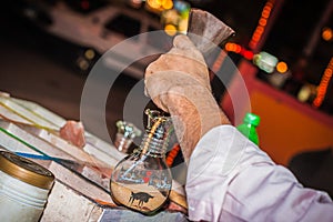 Making a picture of sand in a bottle. Male hands closeup. Hurghada, Egypt.