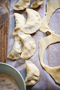 Making `Pierogi` - traditional, christmas Polish dumplings stuffed with mushrooms and sour cabbage filling. Rolled butter dough wi
