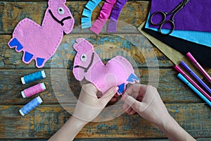 Making pink lama. Sewing toys from felt with your own hands. DIY concept for children. Handmade crafts. Step 3. Sew all details of