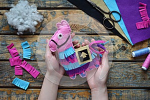 Making pink lama. Sewing toys from felt with your own hands. DIY concept for children. Handmade crafts. Step 6. Finished toy