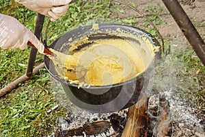Making polenta in a traditional cast-iron pan in Transylvania, Romania
