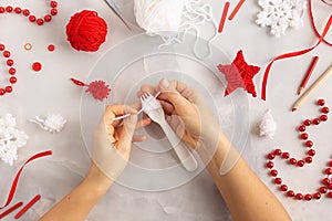 Making pom-poms from red and white threads. Ideas of Christmas decoration diy with kids