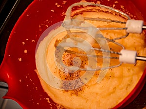 Making potato mash with mixer. Spices on top before mixing in a red bowl