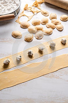 Making ravioli with ricotta and herb filling. Fresh pasta dough.