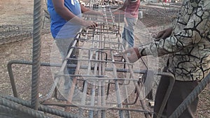 Making RCC Column after Design on Site. Construction workers attach steel rings to columns and beams. - Reinforcement concrete