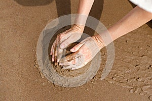 Making sandcastle on the beach. Leisure creative activity