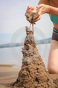 Making sandcastle on the beach. Leisure creative activity