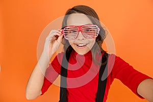 Making selfie. party glasses for fun. kid fashion concept. Staying focused with glasses. cool looking pupil orange
