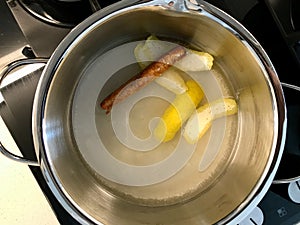 Making Sherbet with Cinnamon Stick, Lemon Peel and Water in Pot for Pasteis de Nata or Belem Tart. Portuguese Custard made with