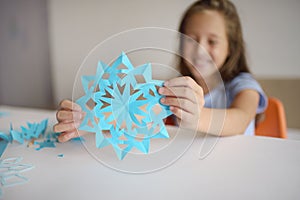 Making of snowflakes from blue paper.