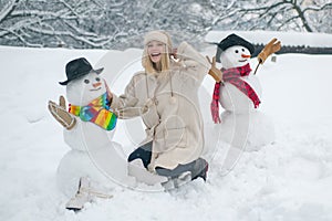 Making snowman and winter fun for people. Winter waman with Snowman on snow background. Snowman and snow day.